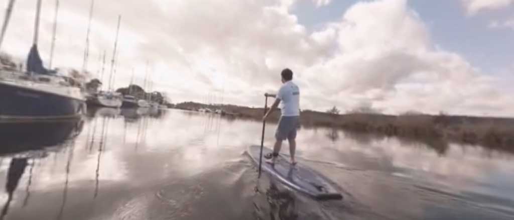 a man stood up paddle boarding in a harbour