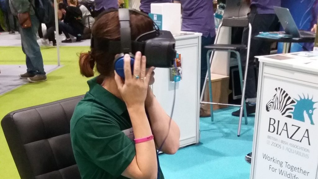 a woman sat with a VR headset and headphones