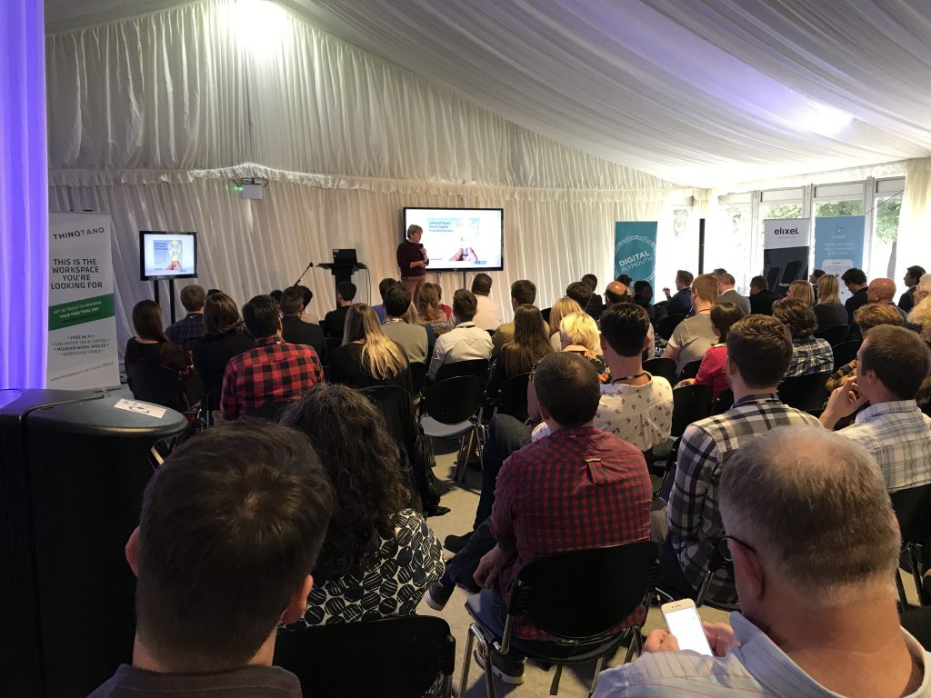 a person presenting a slideshow to a large group of people sat down