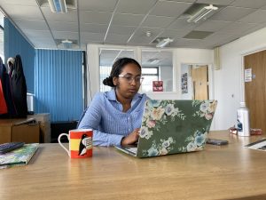 woman at desk with a laptop and mug