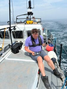 A man on a boat wearing a life jacket setting up a 360 drone