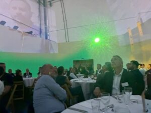 a group of people sat at dinner tables looking around in a 360 immersive media dome