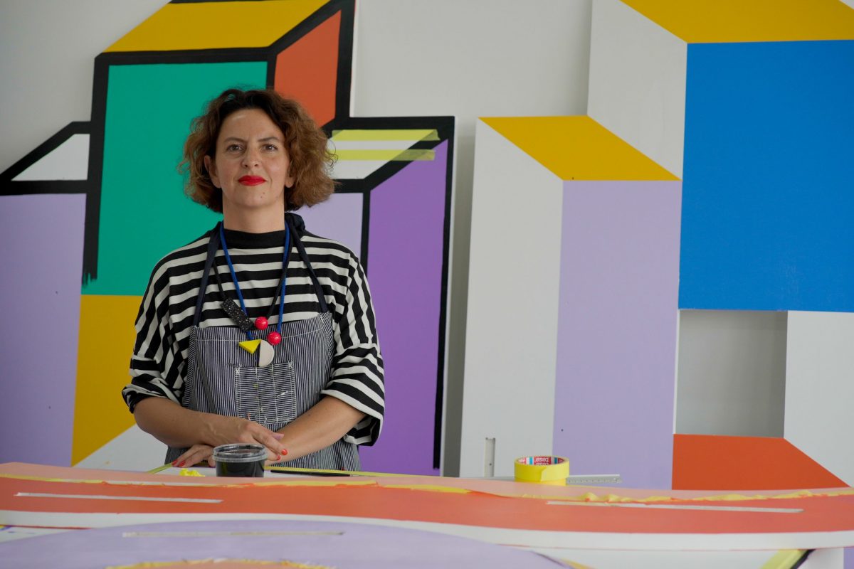 Camille walala smiling with her artwork in the background