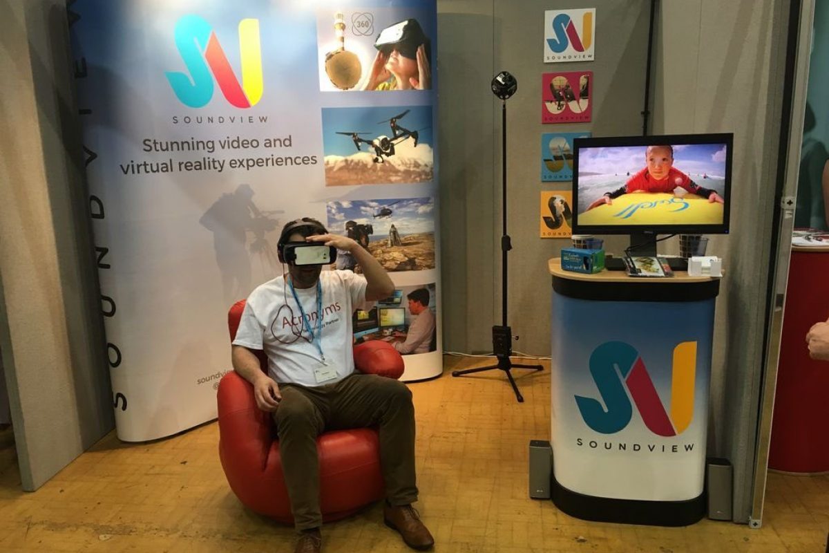 A man setup in front of SoundView's business show stall setup wearing a VR headset