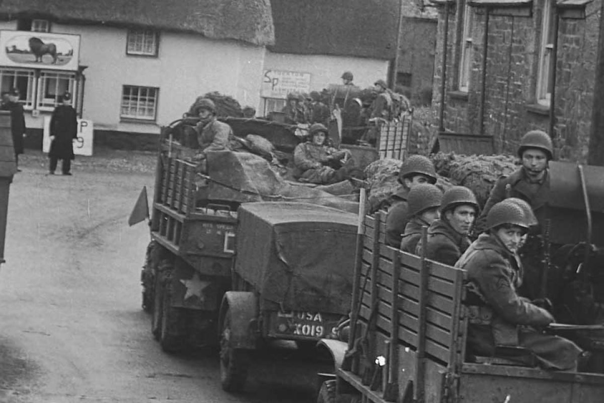 a black and white image of soldiers on the back vechiles