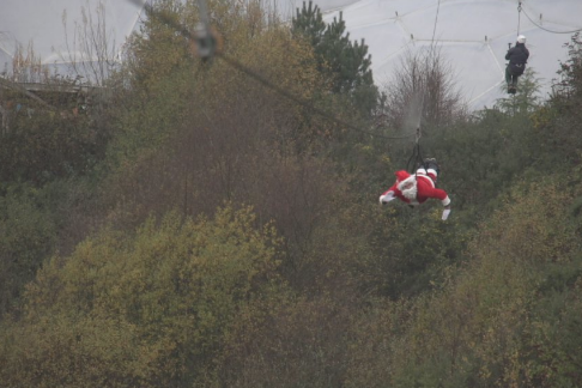 Father Christmas on a zip line over treetops