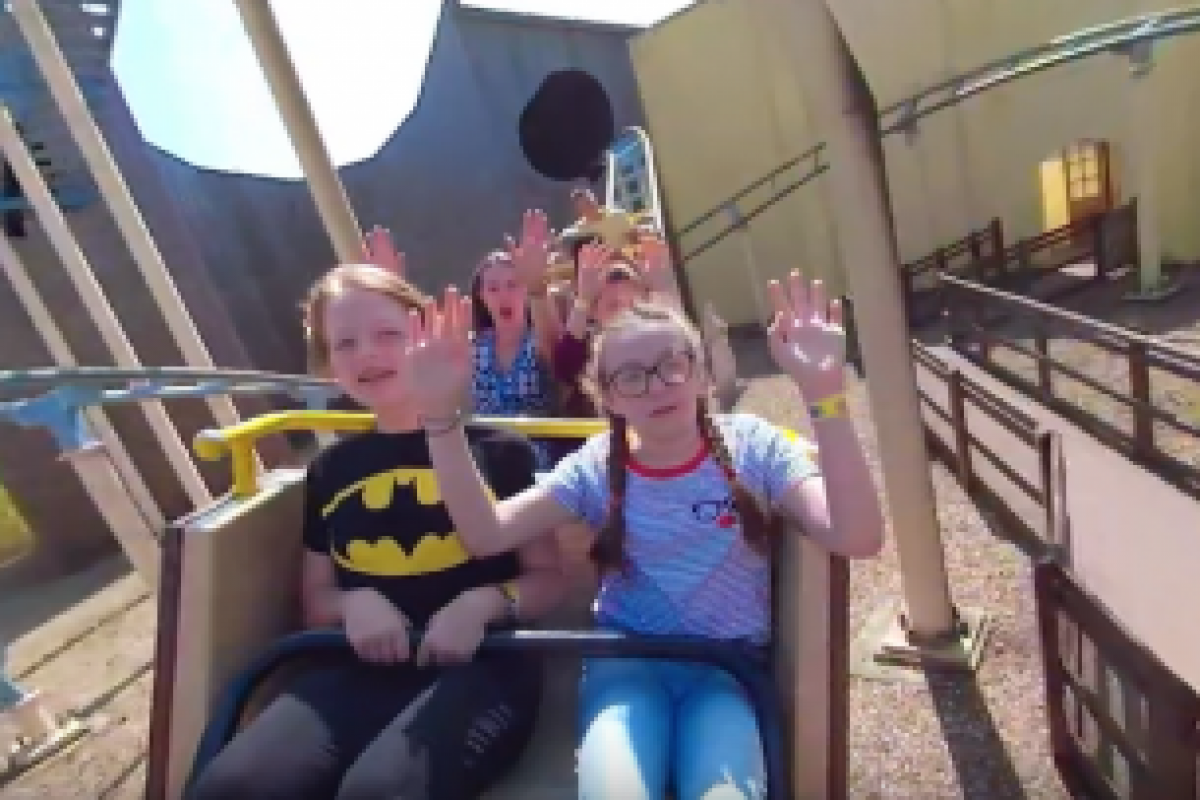 people on a roller coaster celebrating with their arms up
