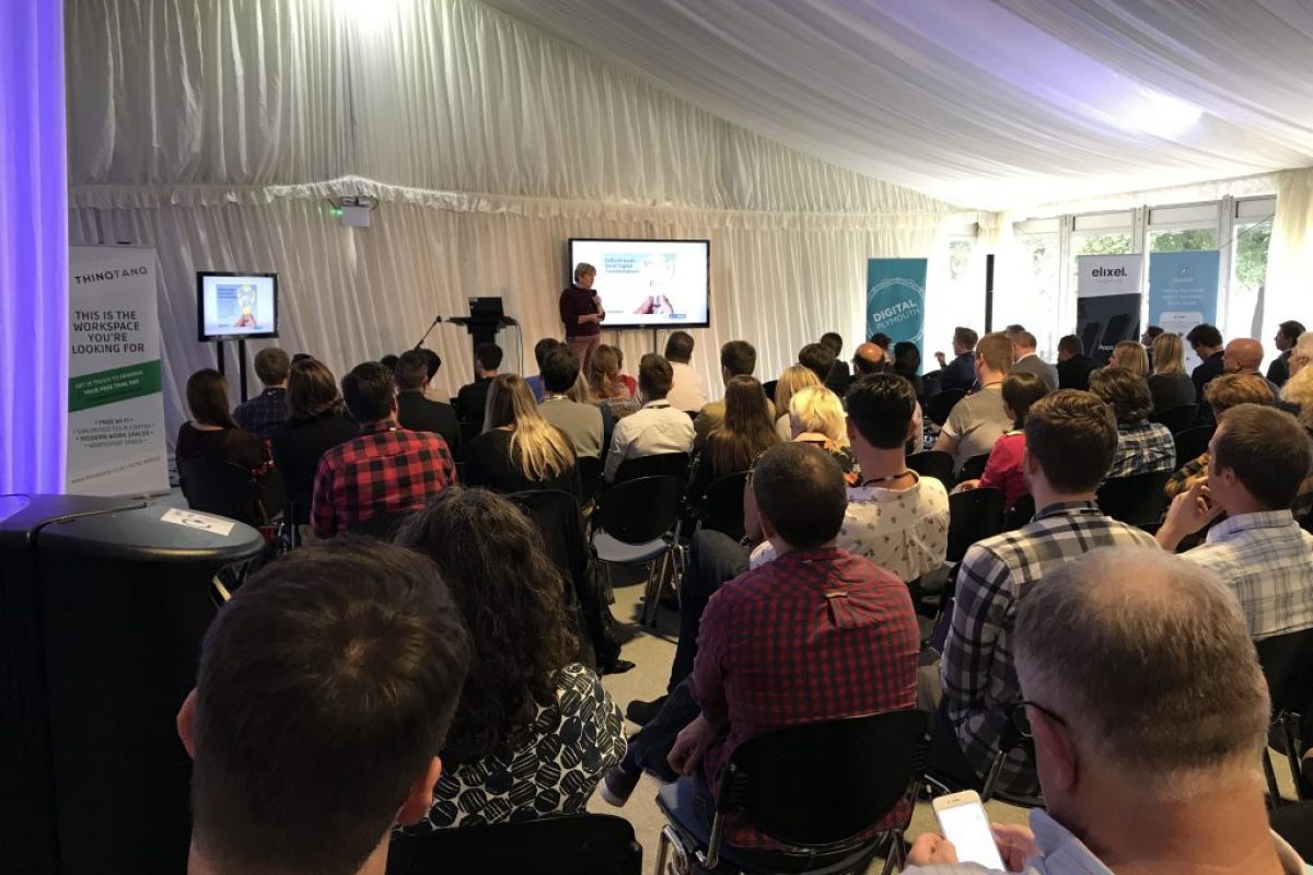 a person presenting a slideshow to a large group of people sat down